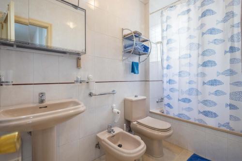 ein Badezimmer mit Waschbecken, Toilette und Spiegel in der Unterkunft Meraki Agaete Puerto De Las Nieves in Agaete