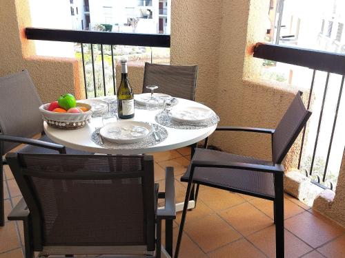 - une table avec une bouteille de vin et un bol de fruits dans l'établissement Apartment Dominica-4 by Interhome, au Barcarès