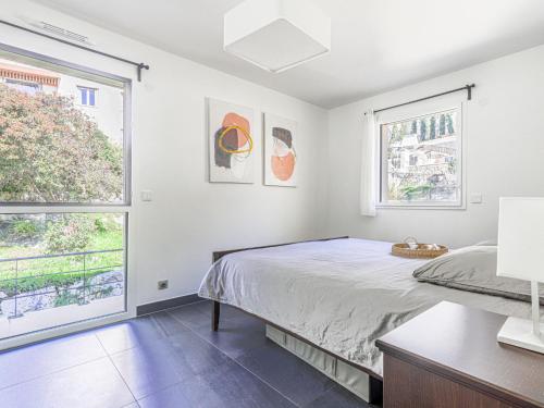 une chambre avec un lit et deux fenêtres dans l'établissement Apartment Prestige view by Interhome, à Èze