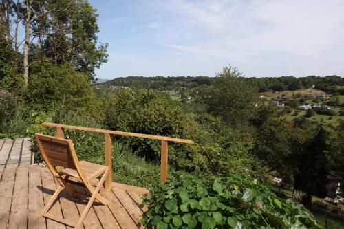 une chaise en bois assise sur une terrasse en bois dans l'établissement Hill Cottage, à Équemauville