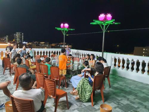 a group of people sitting around a table on a roof at Khách Sạn Đại Dương FLC Sầm Sơn in Sầm Sơn