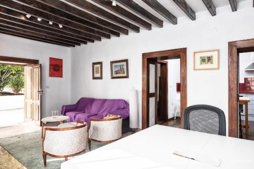 Una sala de estar con un sofá morado y una mesa en Lightbooking Panchita Villa de Mazo Piscina, en Mazo