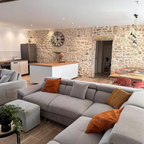 un salon avec un canapé et une cuisine dans l'établissement Le Domaine du Rossignol, à Bonlieu-sur-Roubion