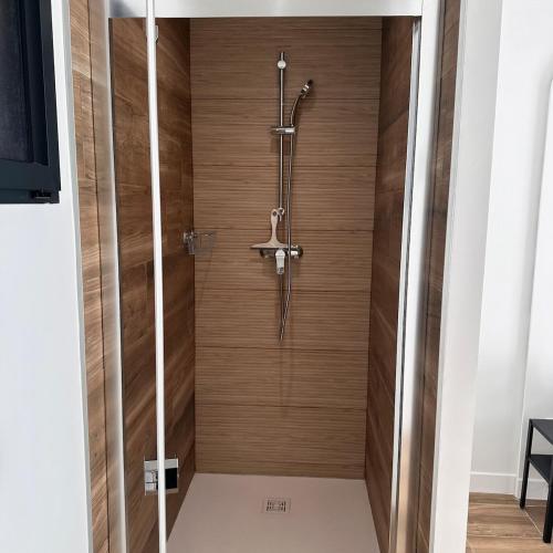 d'une douche avec un mur en bois. dans l'établissement Le Domaine du Rossignol, à Bonlieu-sur-Roubion