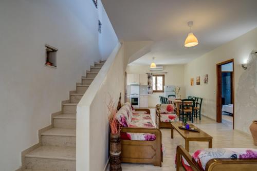 a living room with stairs leading to a dining room at Crete Essence Villas - Lagkada in Makry Gialos