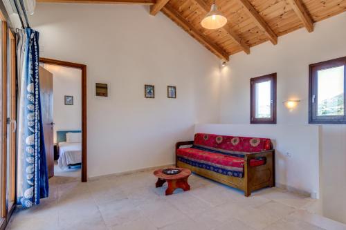 a living room with a red couch and a table at Crete Essence Villas - Lagkada in Makry Gialos