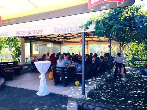 a group of people sitting at a restaurant at Apartments Villa Bare in Kastav
