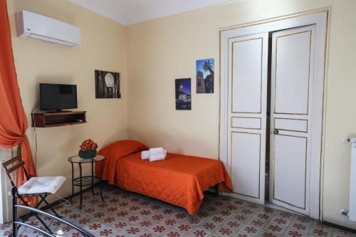 a bedroom with a bed with an orange blanket at Antica Dimora in Palermo