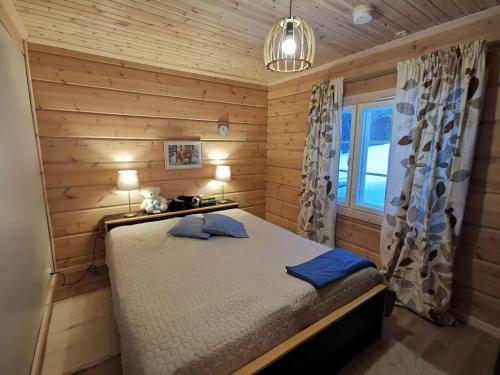 a bedroom with a bed in a wooden room at Syötteen Uuvana in Syöte