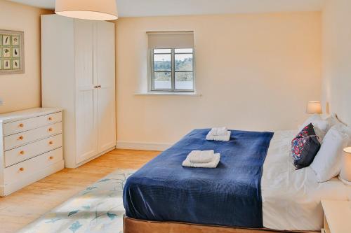 a bedroom with a blue bed with towels on it at Rock Farm Slane - Limehouse in Slane