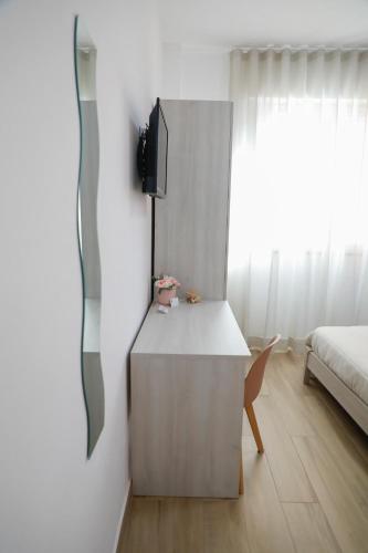 a bedroom with a bed and a desk with a tv at Magi Rooms in Scafati