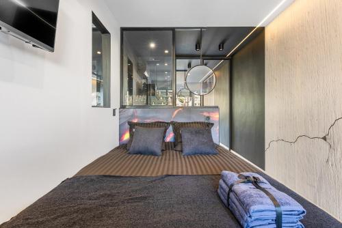 une chambre avec un grand lit avec des oreillers bleus dans l'établissement Le Volcanic - Coursives - Port Nature 2, au Cap d'Agde