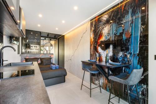 Il comprend une cuisine et un salon orné d'une peinture murale. dans l'établissement Le Volcanic - Coursives - Port Nature 2, au Cap d'Agde