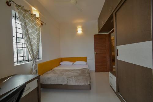 a small bedroom with a bed and a kitchen at HomeSlice Whitefield in Bengaluru