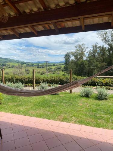 a hammock in a yard with a view of a field at Pousada Serra dos Sicalis in Serra Negra