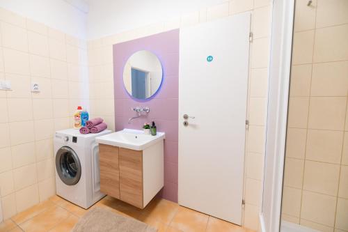 a bathroom with a washing machine and a sink at 7nights Apartments Dominikánské naměstí in Brno