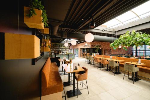 a restaurant with tables and chairs in a room at Chalet 2124 - Camping De Schatberg in Sevenum