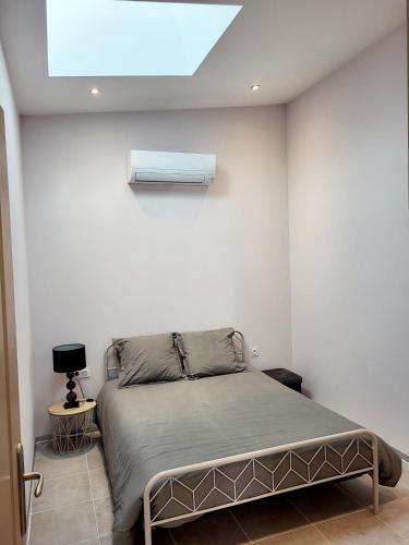 a bedroom with a bed with a air conditioner on the wall at Maison au calme - Clim - Wi-Fi - terrasse et cours in Salles-d'Aude