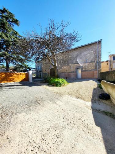 an empty parking lot in front of a building at Maison au calme - Clim - Wi-Fi - terrasse et cours in Salles-d'Aude