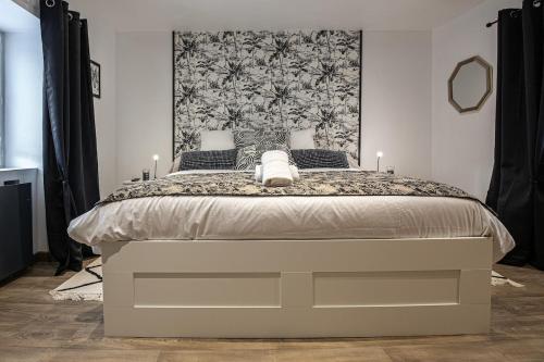 a bedroom with a large bed with a large headboard at T2 centre de la Verpillière in La Verpillière