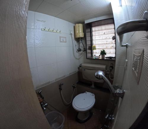 a small bathroom with a toilet and a window at Private 2 Bedroom Cosy Apt Nr Vivanta Malad West in Mumbai