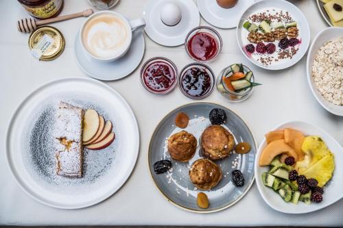 a table with plates of food and cups of coffee at Sporthotel Zoll in Vipiteno