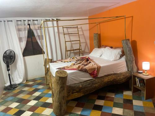 a bedroom with a bed with a wooden frame at La ferme de babacar in Toubab Dialaw