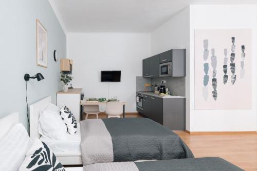 a bedroom with a bed and a kitchen with a desk at 7nights Apartments Dominikánské naměstí in Brno