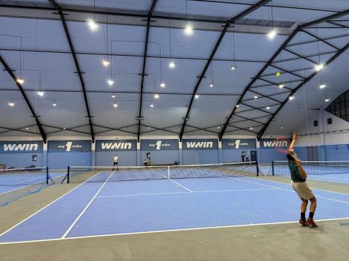 a person serving a tennis ball on a tennis court at Villa Amalia in Široki Brijeg