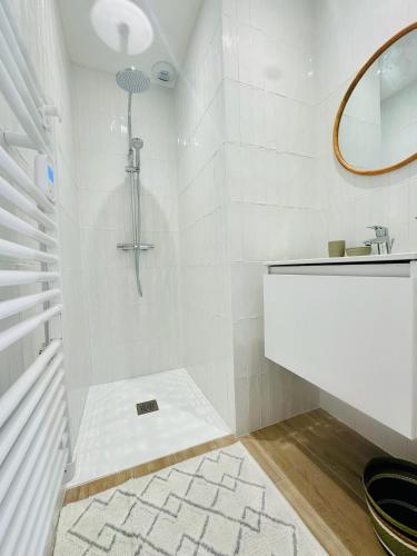 une salle de bain blanche avec une douche et un lavabo dans l'établissement Maison jala Maison 3 ch ,3 sdb Plage Port à pied , Quartier Minimes, à La Rochelle