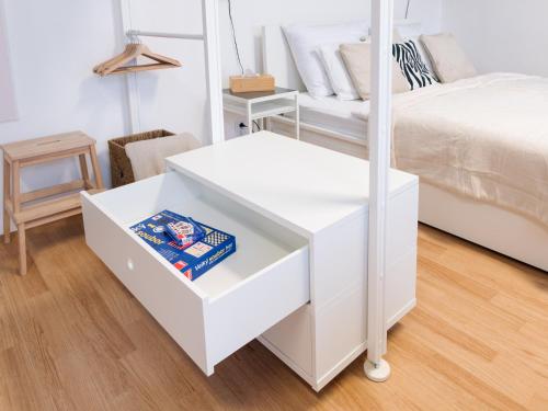 a white bedroom with a bed and a white drawer at 7nights Apartments Dominikánské naměstí in Brno