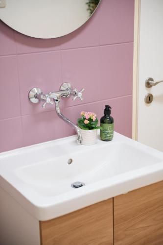 a bathroom sink with a faucet and flowers on it at 7nights Apartments Dominikánské naměstí in Brno