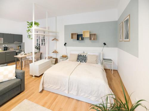 una camera da letto bianca con un letto e un divano di 7nights Apartments Dominikánské naměstí a Brno
