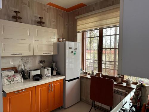 a kitchen with a white refrigerator and a window at Gabala Riverside House in Gabala