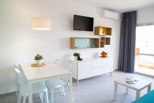 a living room with a white dining room table and chairs at RVApartaments Estartit Confort in L'Estartit