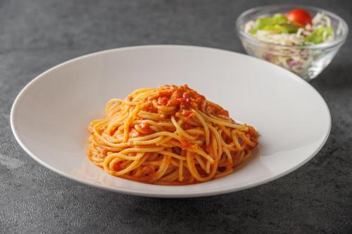 a white plate of spaghetti with a bowl of salad at The Royal Park Canvas - Kobe Sannomiya in Kobe