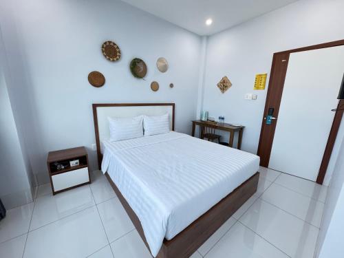 a white bedroom with a bed and a mirror at An Nhiên Hotel in Tây Ninh