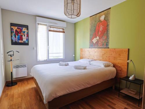 une chambre avec un grand lit et un tableau au mur dans l'établissement Ti Coco, à Perros-Guirec