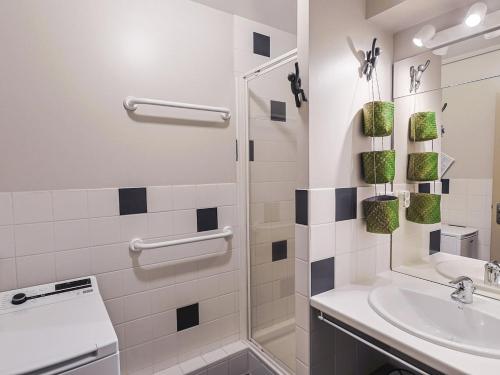 une salle de bain blanche avec un lavabo et une douche dans l'établissement Ti Coco, à Perros-Guirec