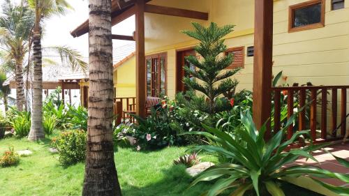 a house with palm trees and plants in front of it at Free Beach Resort in Phu Quoc