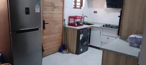 a small kitchen with a refrigerator and a stove at Jobecky luxury apartment in Lekki