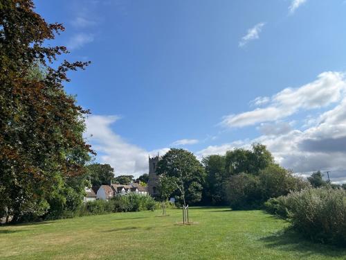 a field with trees and a building in the background at Fun 7 holidays entire flat in Huntingdon