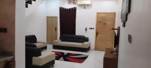 a living room with two chairs and a door at Jobecky luxury apartment in Lekki