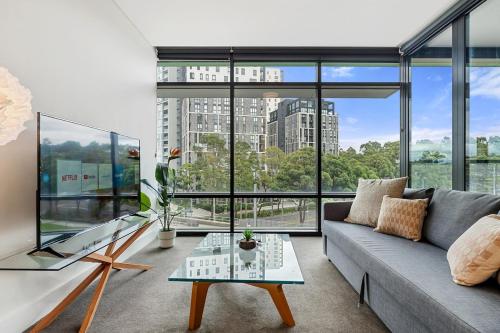a living room with a couch and a large window at 47OP Elegant Parkview Abnb-Style 2BR Retreat with Free Parking in Sydney