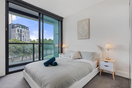 a bedroom with a bed and a large window at 47OP Elegant Parkview Abnb-Style 2BR Retreat with Free Parking in Sydney