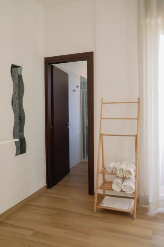 a room with a shelf with towels and a door at Magi Rooms in Scafati