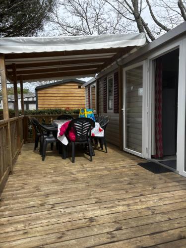 une terrasse avec des chaises, une table et une tente dans l'établissement Mobil home 8 places, à Gastes