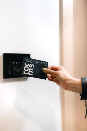 a person holding a sticker on a door at Boutique Macchiato Rooms in Novi Sad