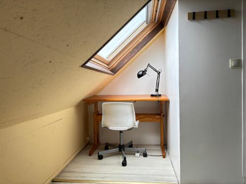 an attic office with a desk and a lamp at Les mouettes Apt duplex indépendant dans maison spacieux petite vue sur mer des chambres belle terrasse aménagée en hauteur près Omaha Beach et Bayeux 800 m plage et 300 m superette in Vierville-sur-Mer