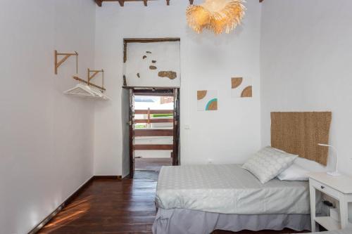 a bedroom with a bed in a room with white walls at Casa Libelvik en pleno centro Galdar con Terraza in Gáldar